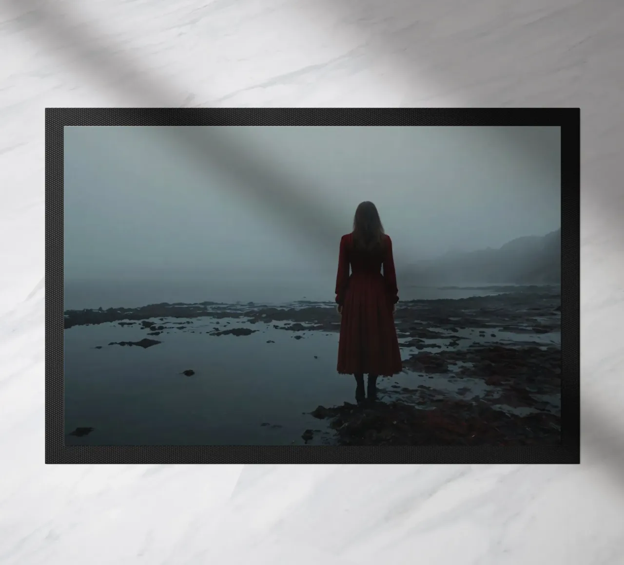 Une femme vêtue d'une robe rouge se tient debout, contemplative, au bord d'une rivière brumeuse. paillasson de DesignDoodle