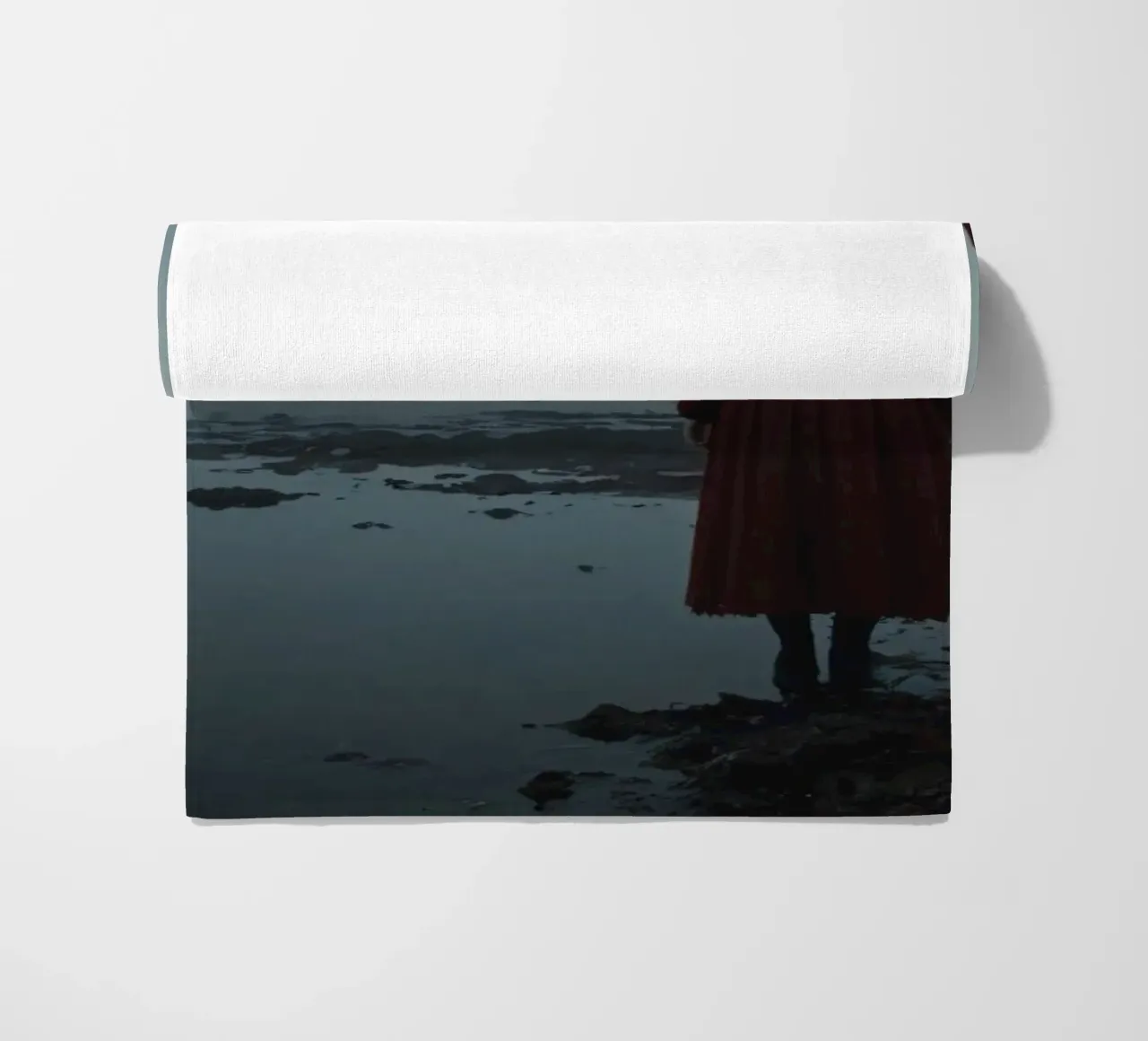 Una donna con un vestito rosso sta in piedi, contemplativa, vicino alla nebbia. telo mare da DesignDoodle