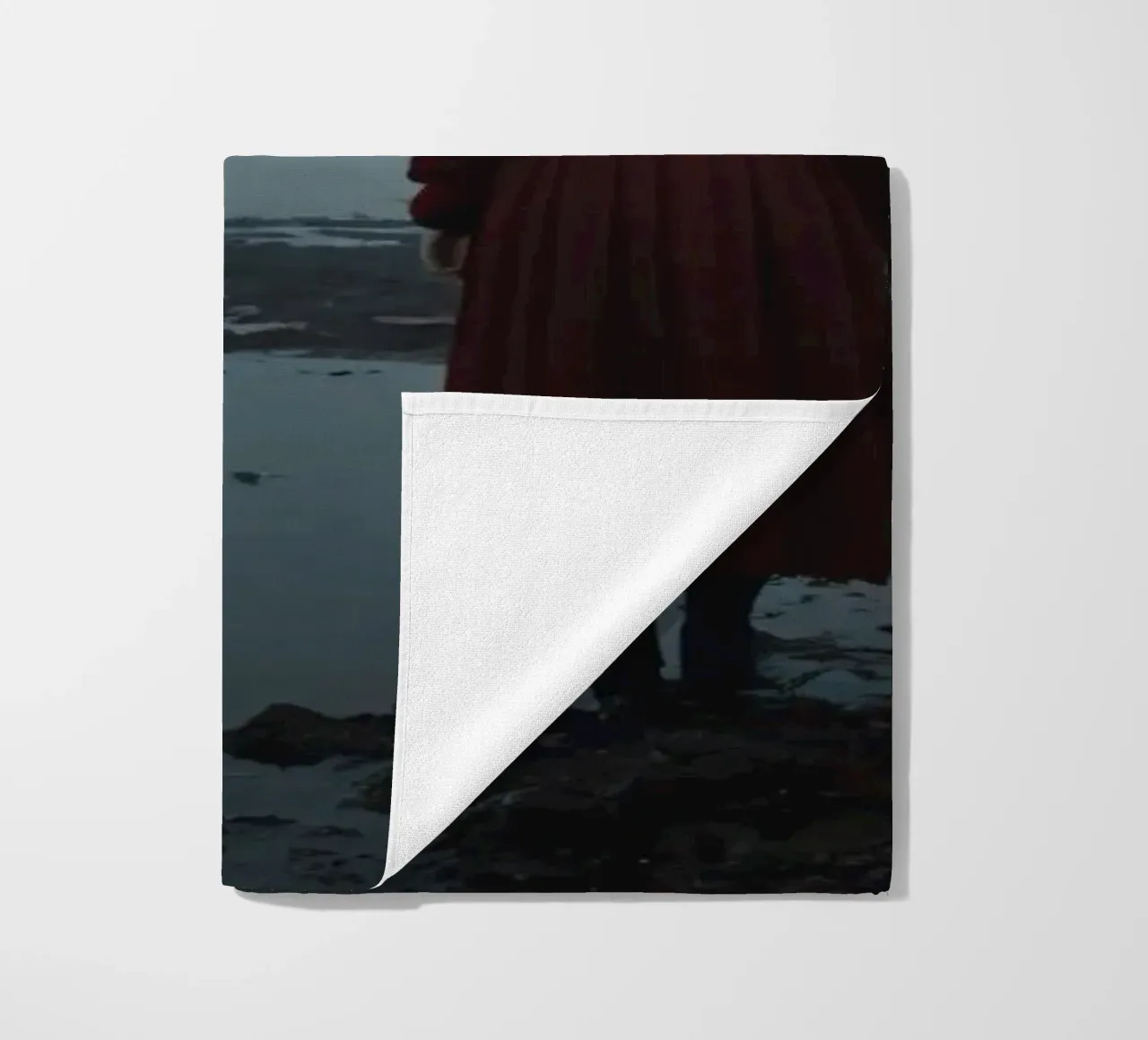 Una donna con un vestito rosso sta in piedi, contemplativa, vicino alla nebbia. telo mare da DesignDoodle