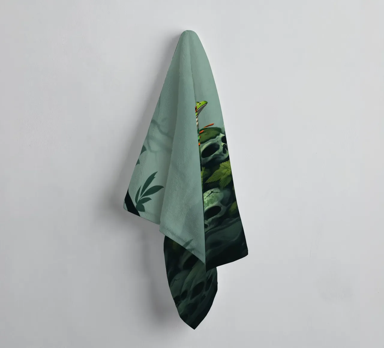 una rana verde siede in cima a un cumulo di teschi circondati dall'oscurità asciugamano da bagno da DesignDoodle