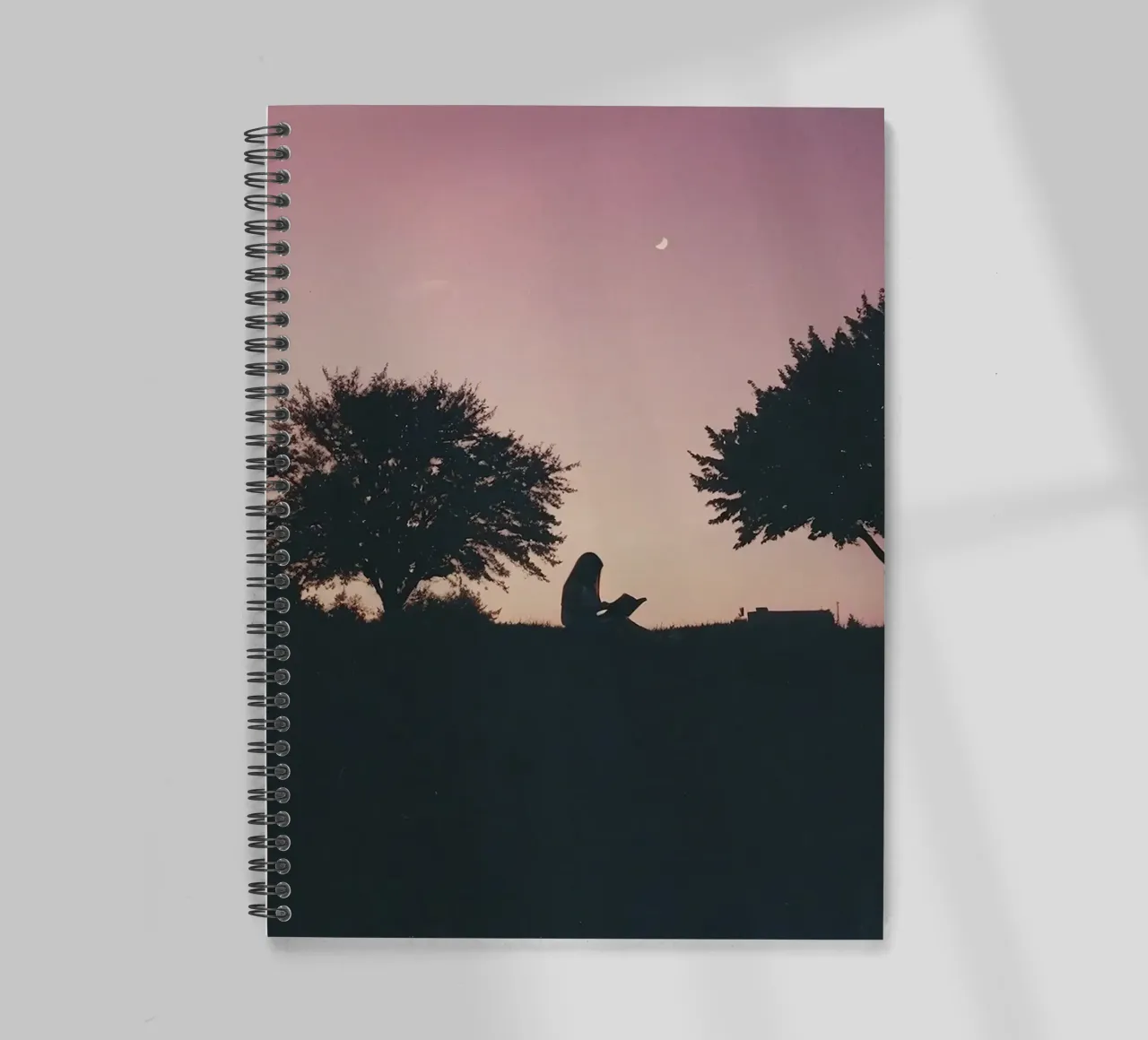 silhouette of a girl reading a book in the yard spiral notebook by serinae