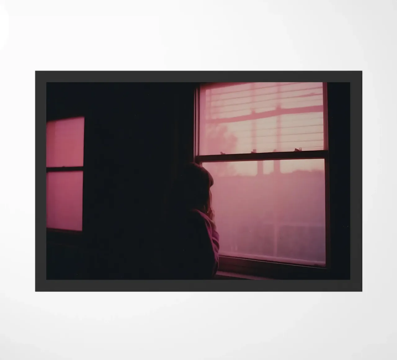 silhouette of a girl looking out the window in a dim room doormat by serinae