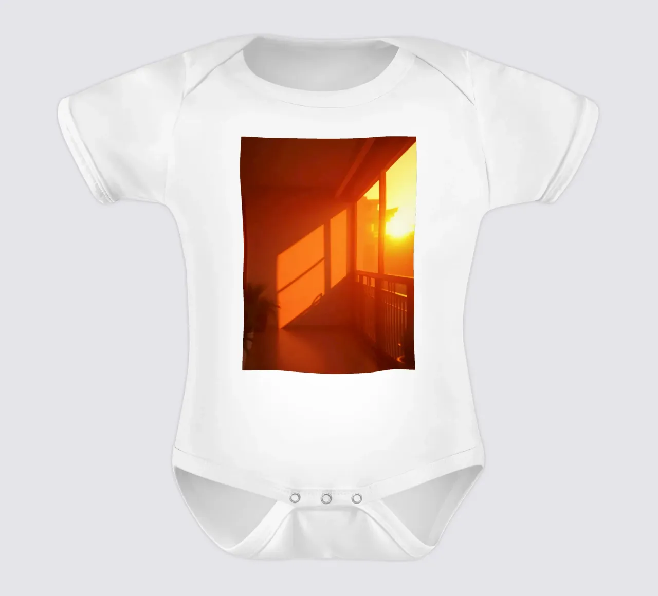 Il tramonto proietta una calda luce arancione sul balcone con le piante body neonato maniche corte da DesignDoodle