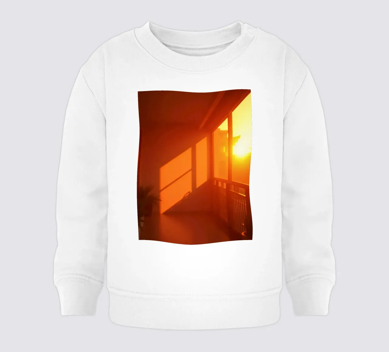 Il tramonto proietta una calda luce arancione sul balcone con le piante felpa neonato da DesignDoodle