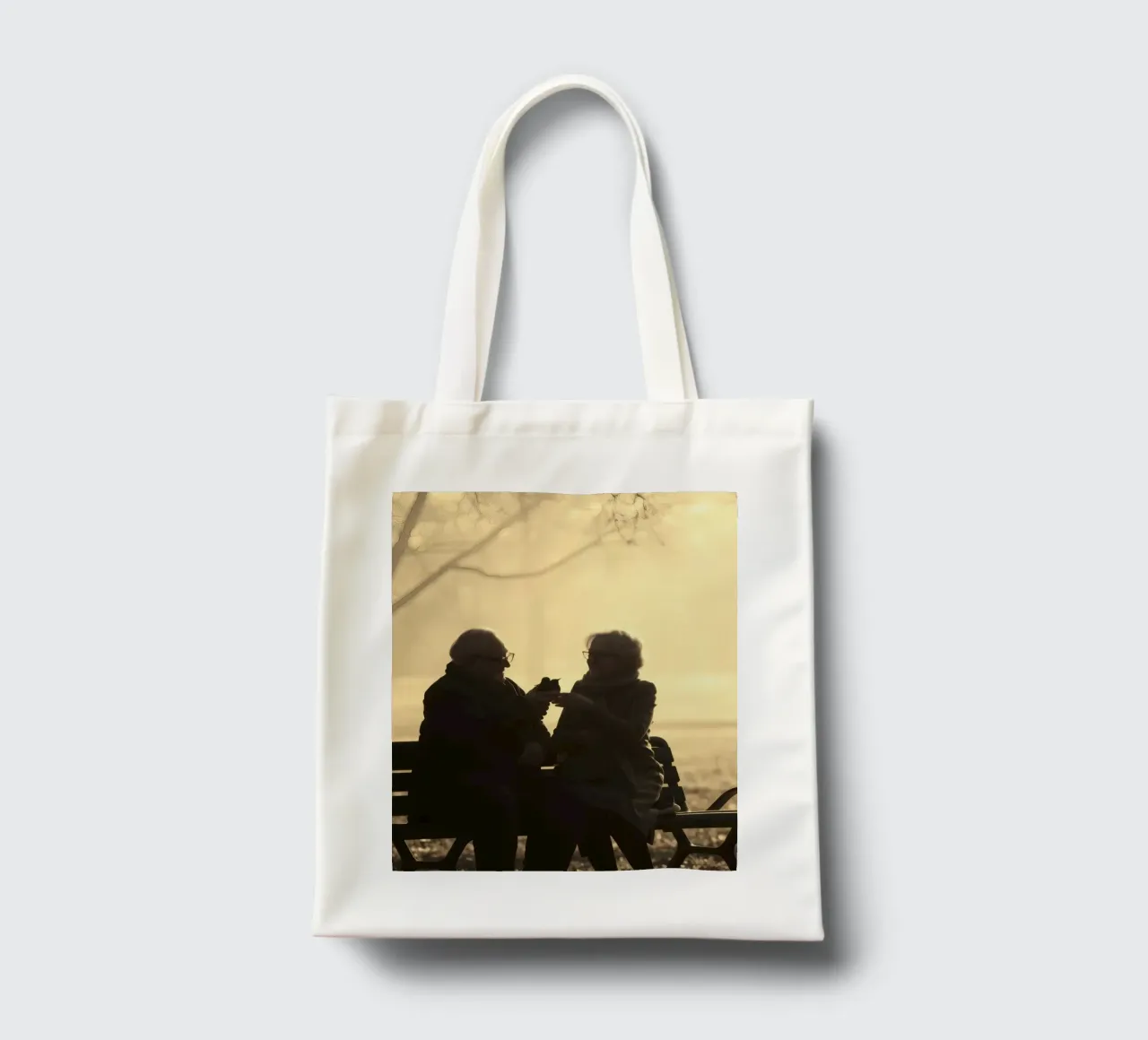 Coppia di anziani si gode un momento di pace nel parco borsa in juta da DesignDoodle