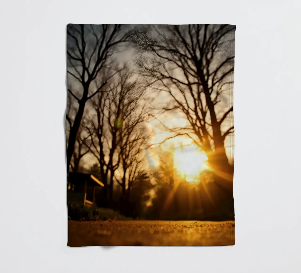 Il tramonto proietta una luce calda attraverso gli alberi lungo un sentiero tranquillo coperta in pile da DesignDoodle