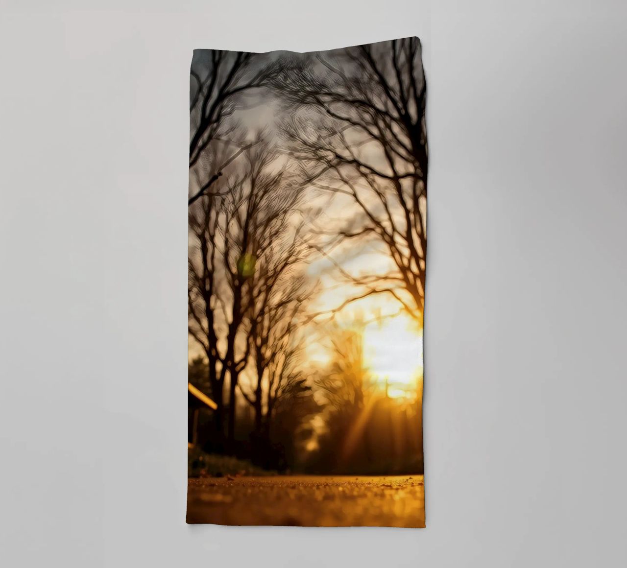 Zonsondergang werpt warm licht door bomen langs rustig pad badhanddoek van DesignDoodle