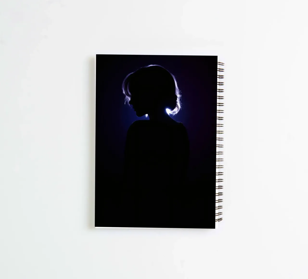 Silhouette of a child against a dark background illuminated spiral notebook by DesignDoodle