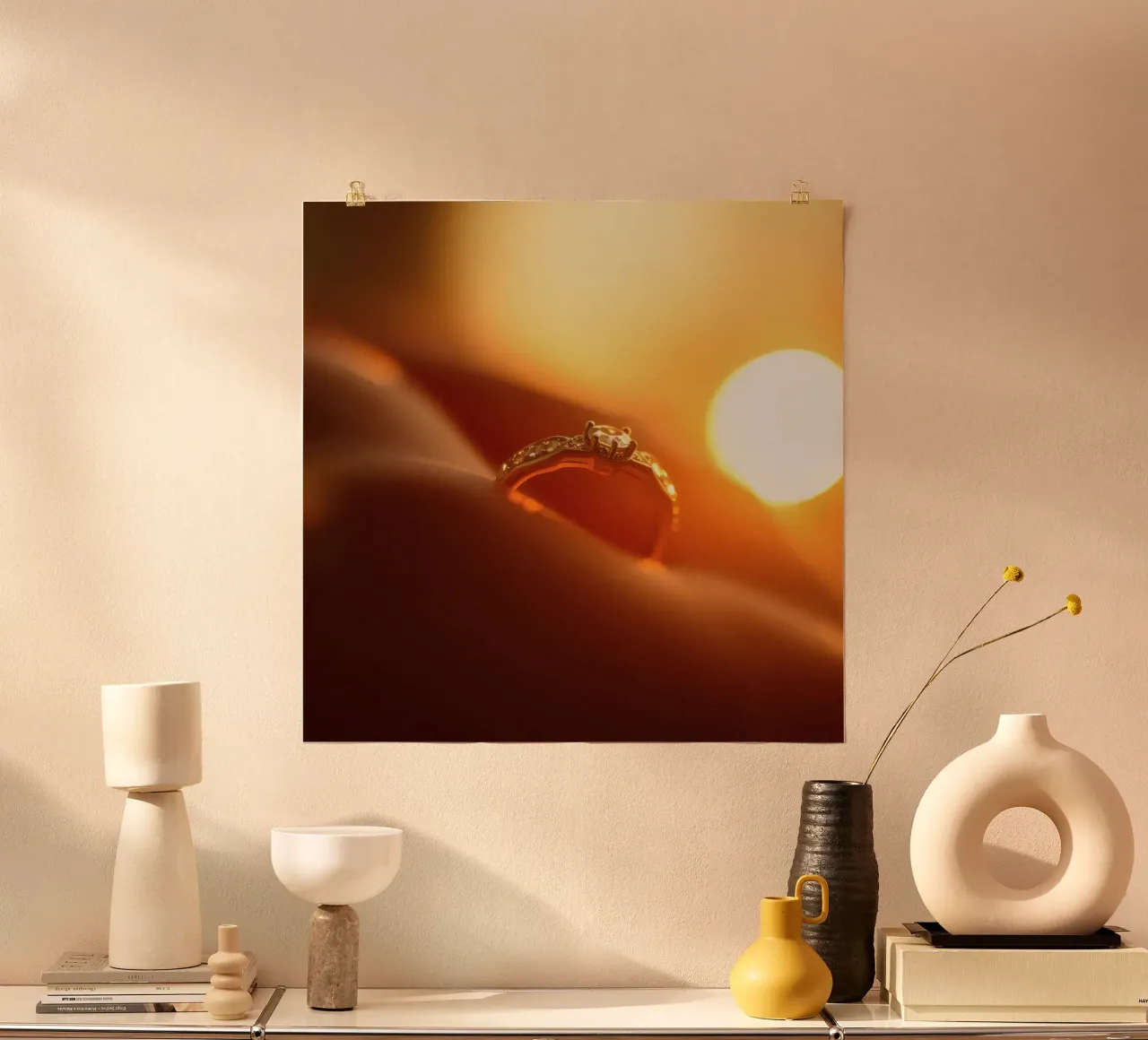 Elegante anillo de oro sostenido en la mano con el resplandor del atardecer iluminando poster con marco de plástico de DesignDoodle