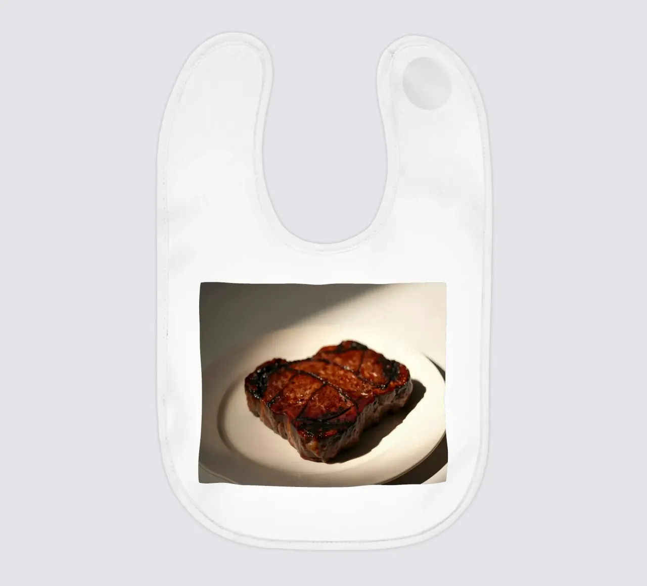 Bistecca perfettamente grigliata servita su un semplice piatto bianco bavaglino da DesignDoodle