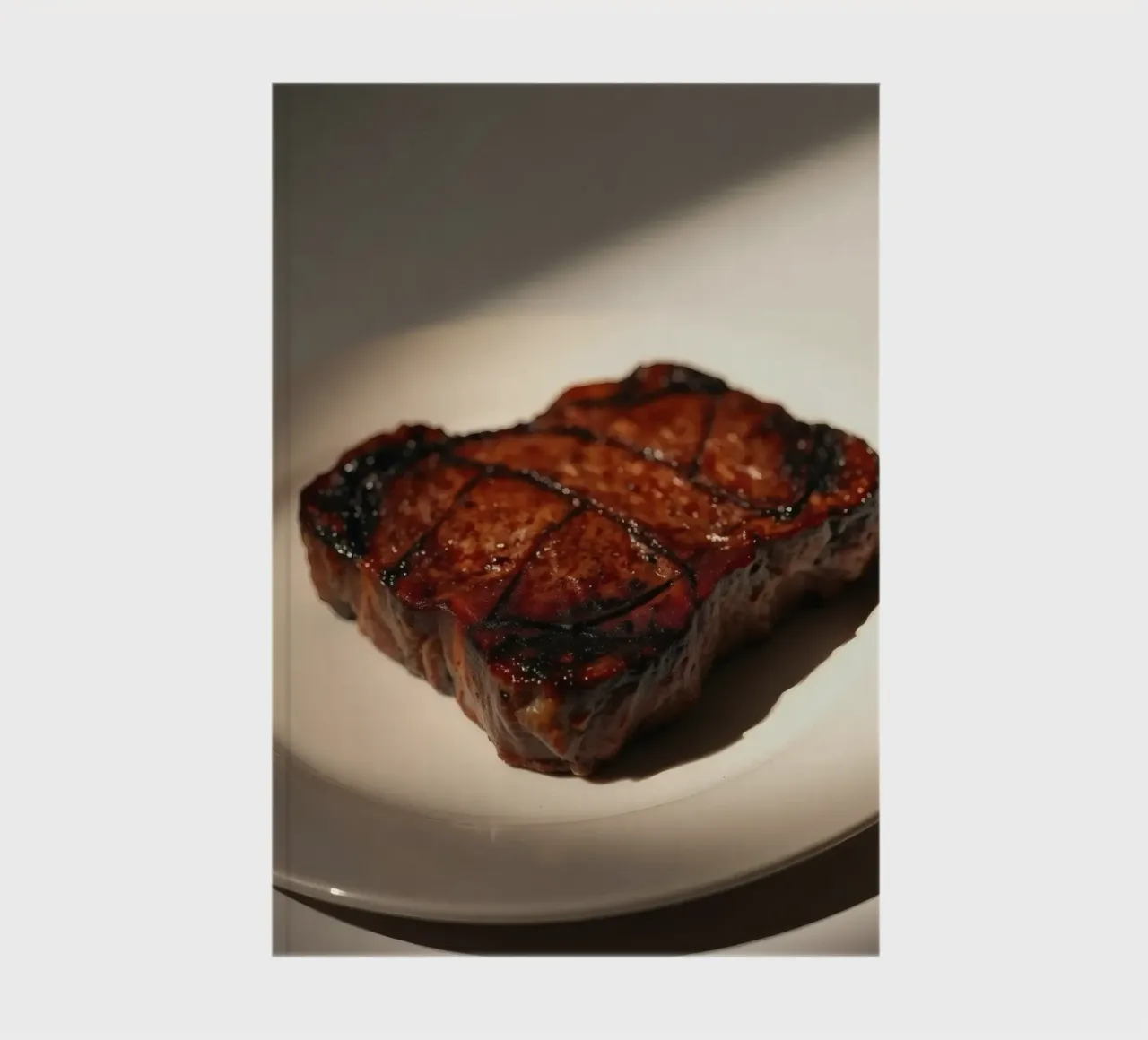 Bistecca perfettamente grigliata servita su un semplice piatto bianco diario da DesignDoodle