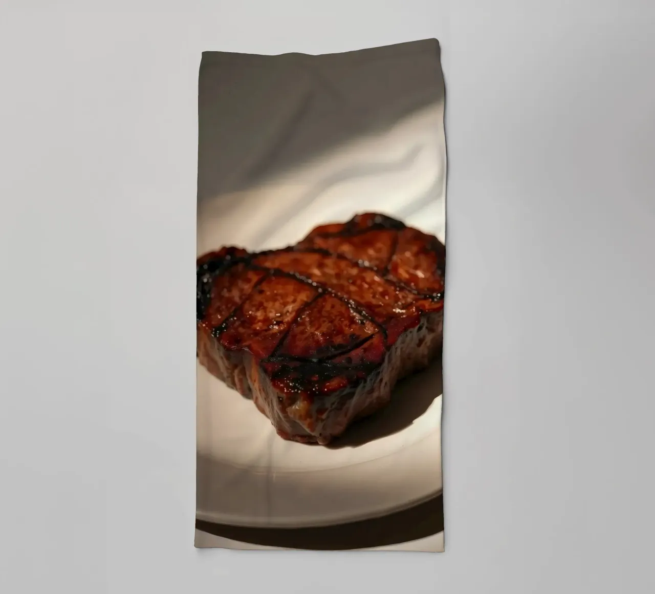 Bistecca perfettamente grigliata servita su un semplice piatto bianco asciugamano da bagno da DesignDoodle