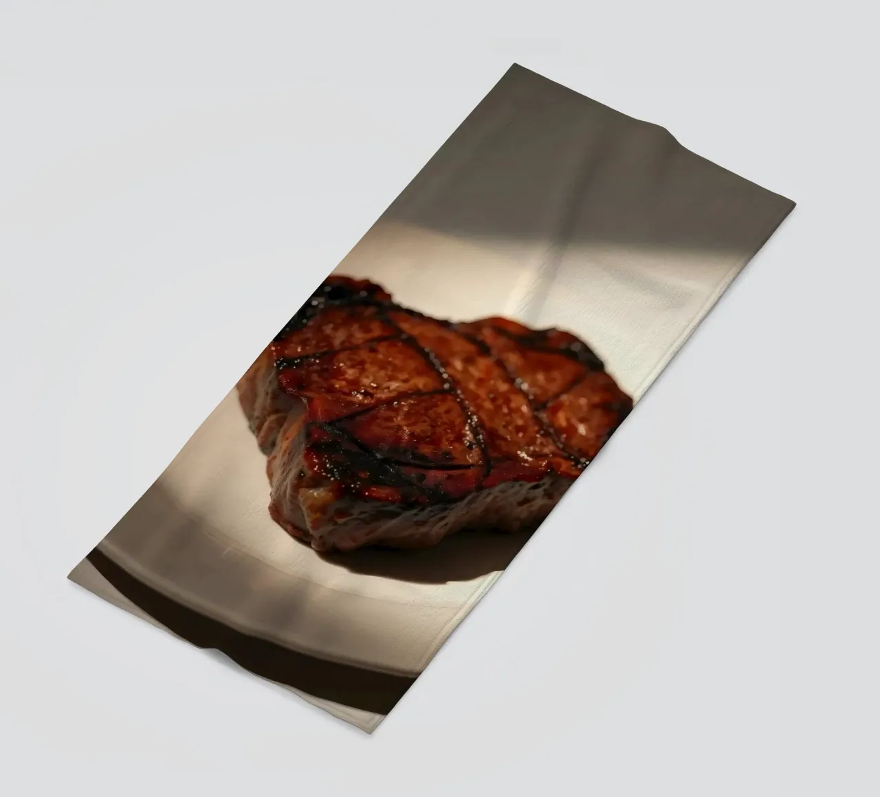 Bistecca perfettamente grigliata servita su un semplice piatto bianco telo mare da DesignDoodle