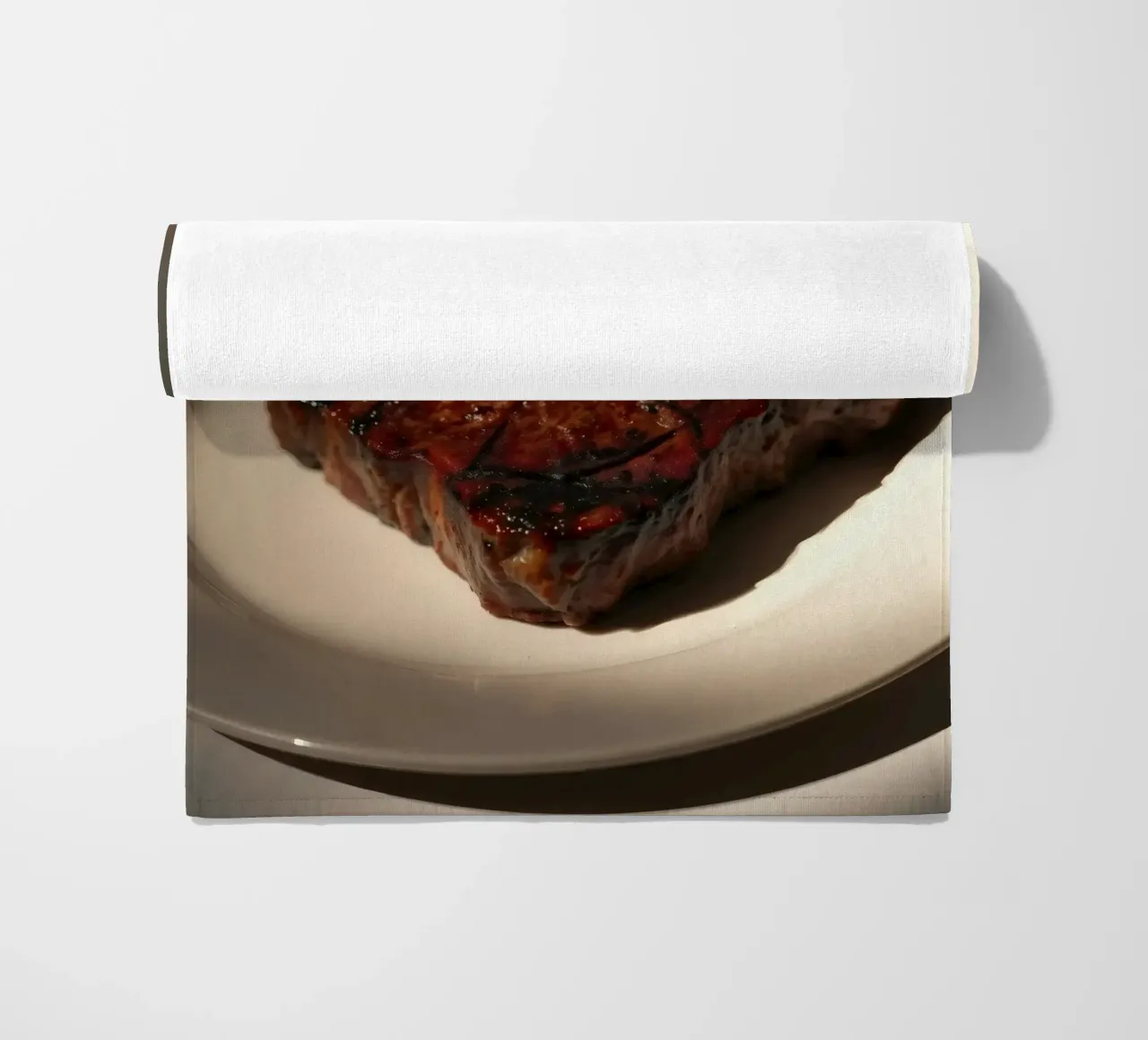 Bistecca perfettamente grigliata servita su un semplice piatto bianco telo mare da DesignDoodle