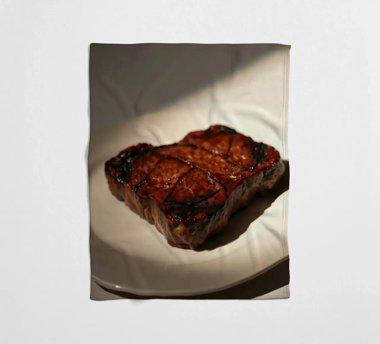 Bistecca perfettamente grigliata servita su un semplice piatto bianco coperta in pile da DesignDoodle