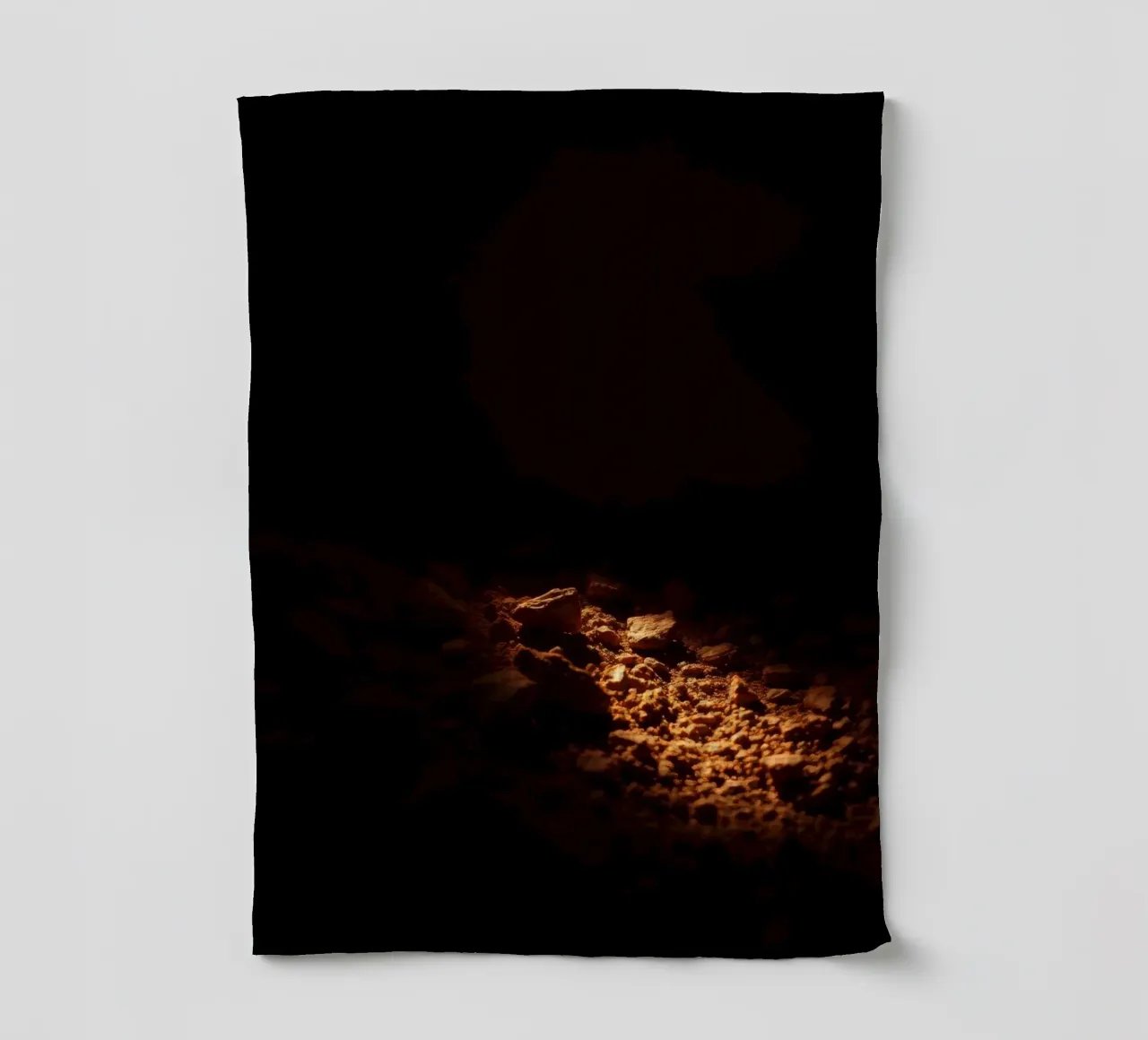 Lumière douce éclairant des textures terreuses à l'intérieur d'une grotte sombre torchon de DesignDoodle