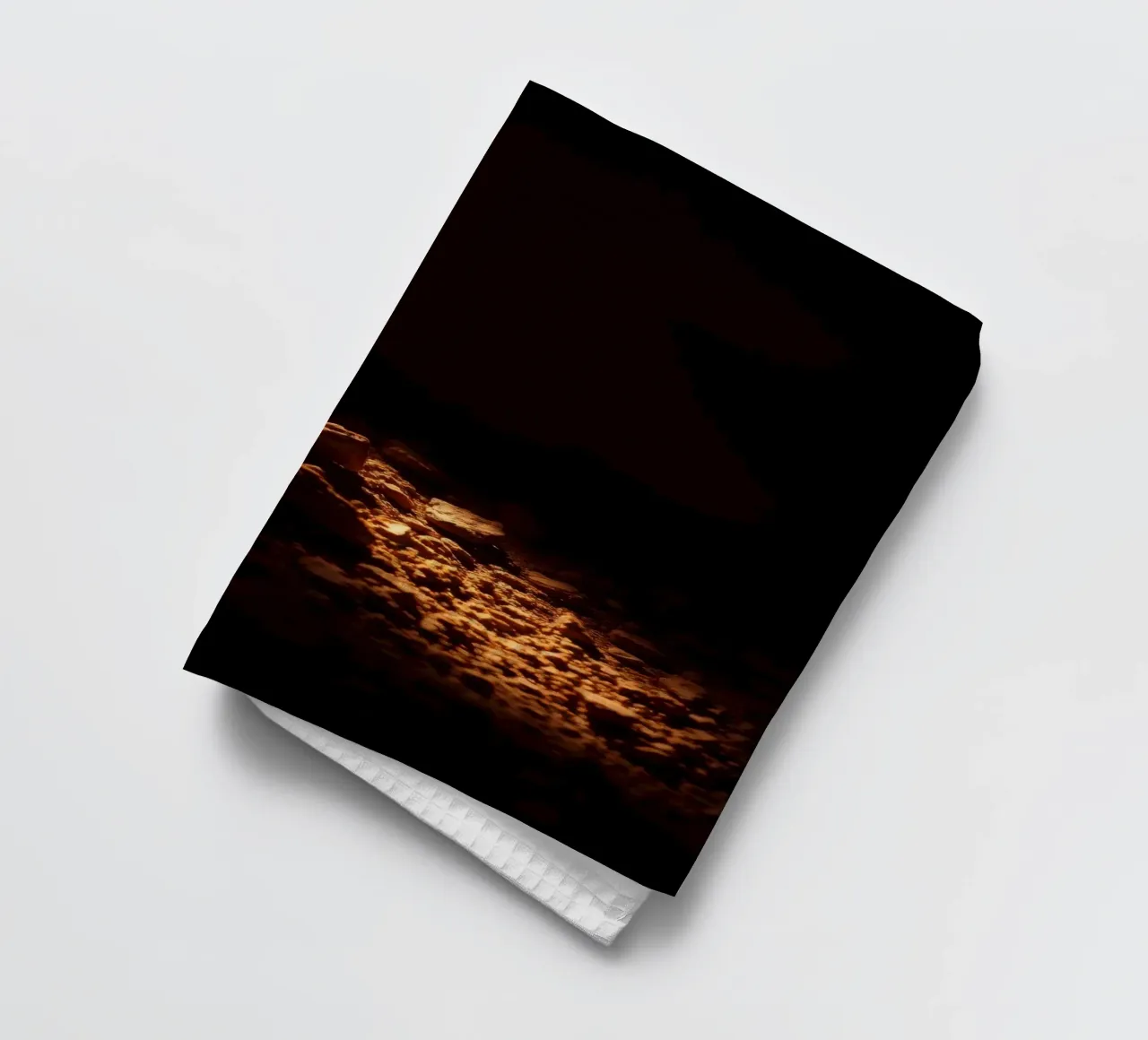 Lumière douce éclairant des textures terreuses à l'intérieur d'une grotte sombre torchon de DesignDoodle