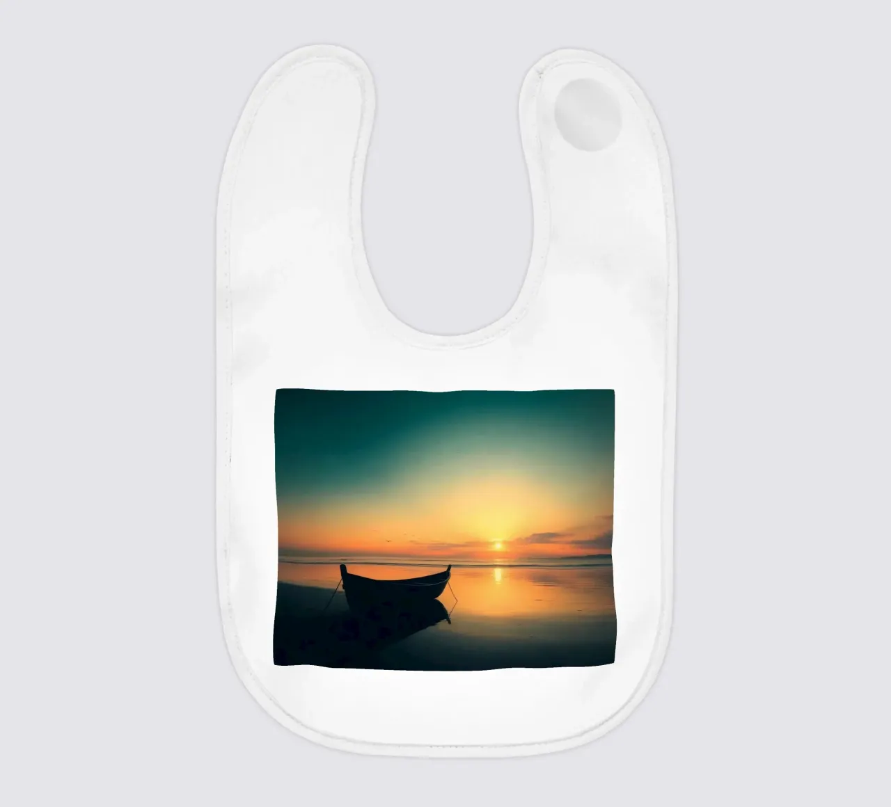 Barca sagomata che riposa sull'acqua calma al tramonto con vibrazioni e colori. bavaglino da DesignDoodle