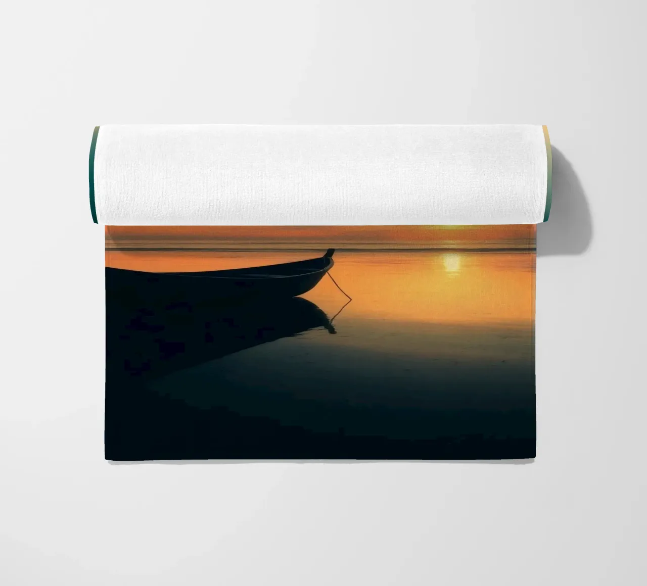 Silhouet boot rustend op kalm water bij zonsondergang met vibran strandhanddoek van DesignDoodle