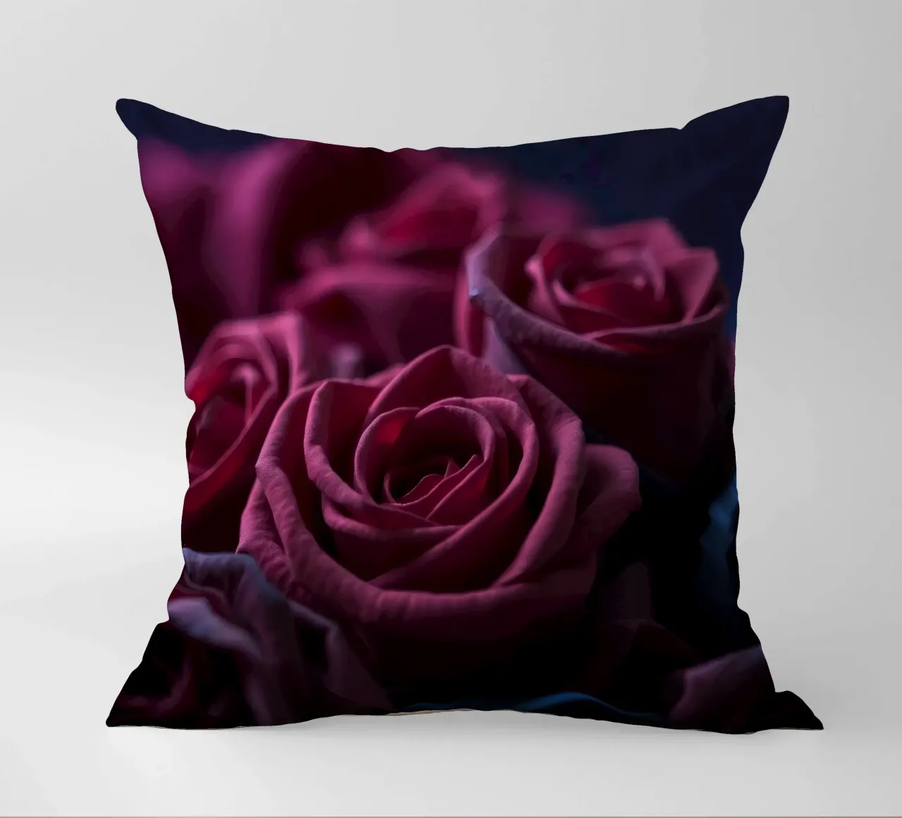 Bouquets of deep red roses arranged artfully in low light decorative cushion by DesignDoodle