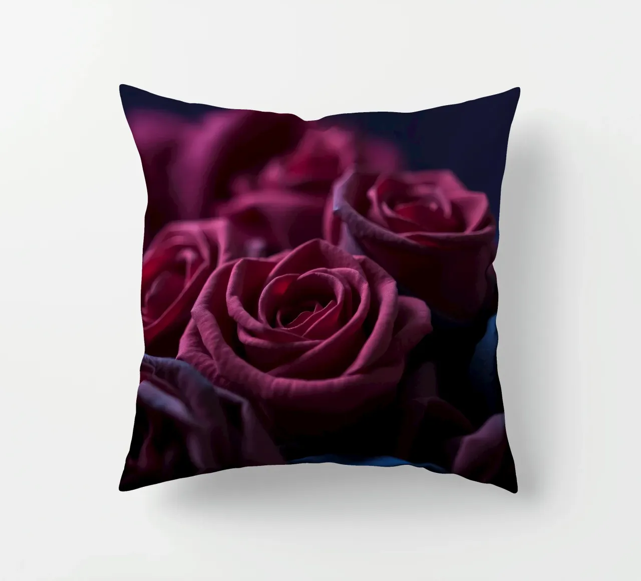 Bouquets of deep red roses arranged artfully in low light decorative cushion by DesignDoodle