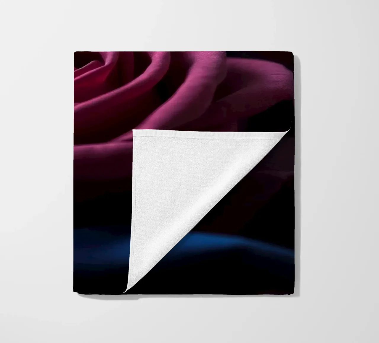 Bouquets of deep red roses arranged artfully in low light beach towel by DesignDoodle