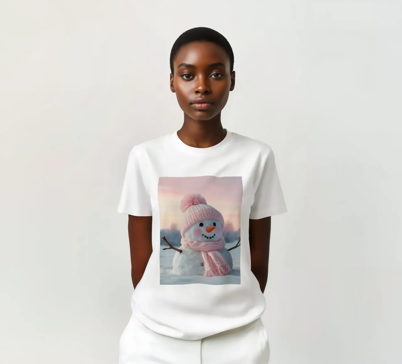 Pupazzo di neve con accessori rosa sorride in un paesaggio invernale t-shirt da DesignDoodle