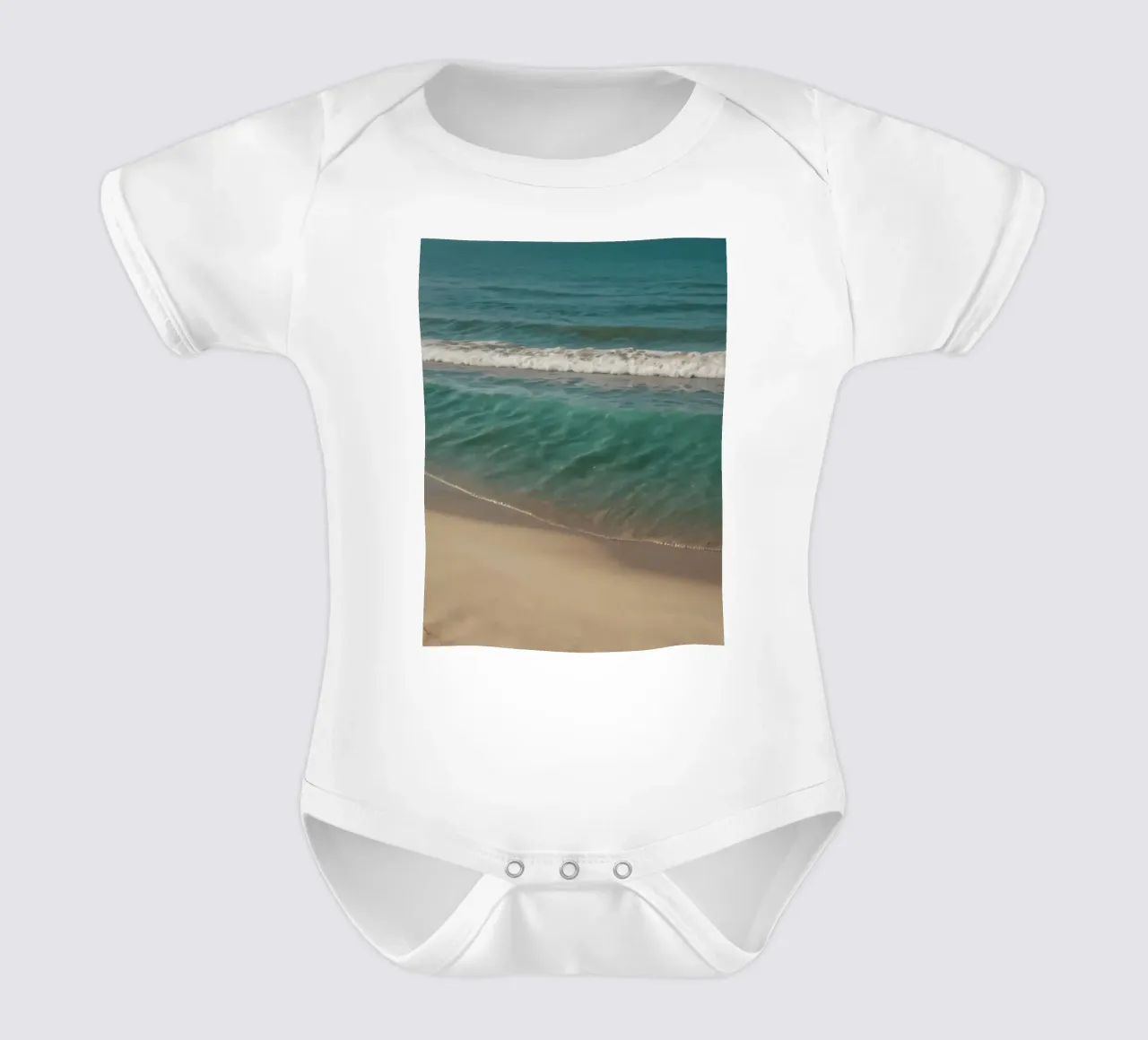 Les vagues s'échouent doucement sur le rivage sablonneux par une journée ensoleillée. body bébé de DesignDoodle