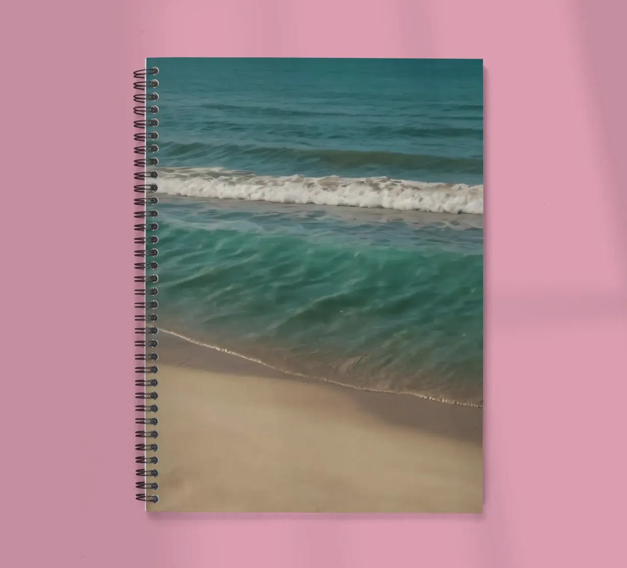 Waves gently lap the sandy shore on a bright sunny day spiral notebook by DesignDoodle