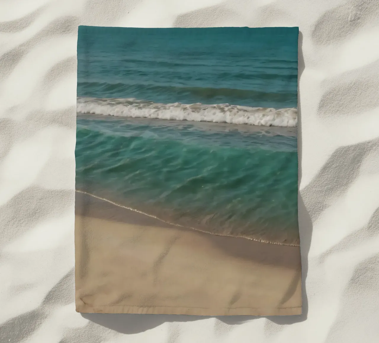 Les vagues s'échouent doucement sur le rivage sablonneux par une journée ensoleillée. serviette de plage de DesignDoodle