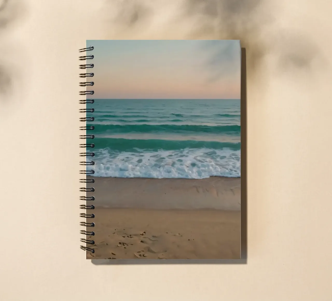 Soft waves lap against golden sand under a colorful sky spiral notebook by DesignDoodle