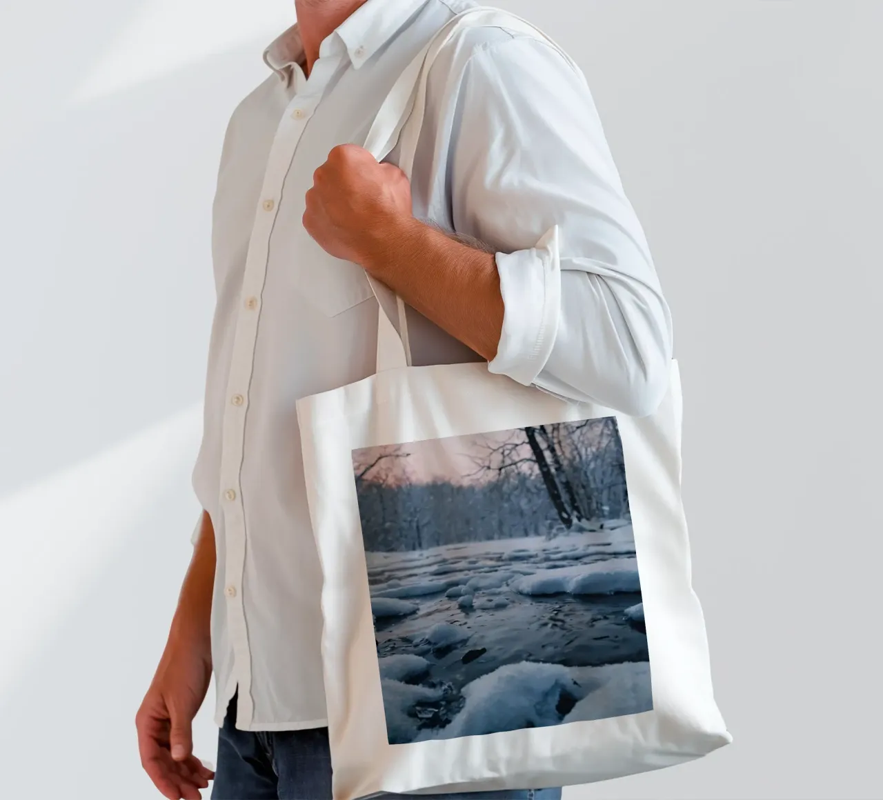 Serene winter landscape with flowing water surrounded snow tote bag by DesignDoodle