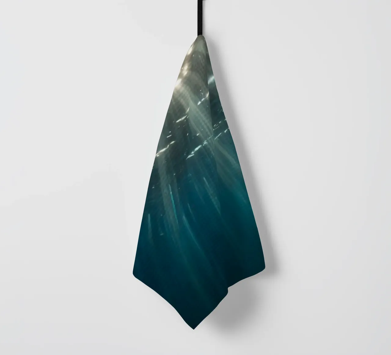 Rays of sunlight penetrate clear water creating tea towel by DesignDoodle