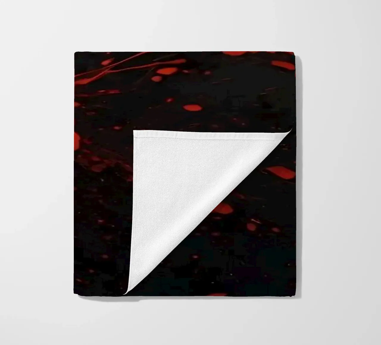 Bold red paint splatters on a dark textured background beach towel by DesignDoodle