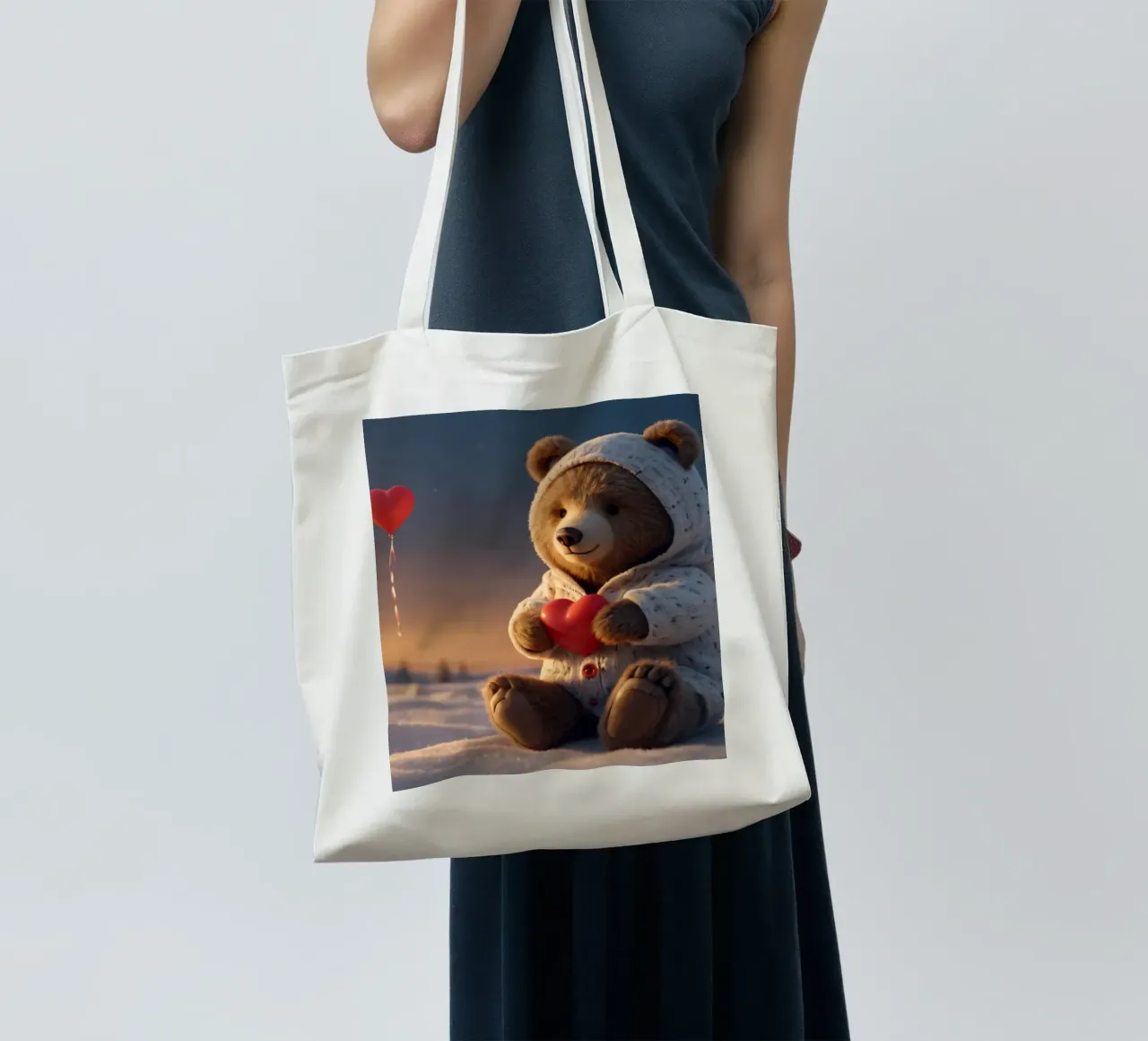 Un orsacchiotto con un'accogliente felpa con cappuccio stringe un cuore in una terra invernale borsa in juta da DesignDoodle