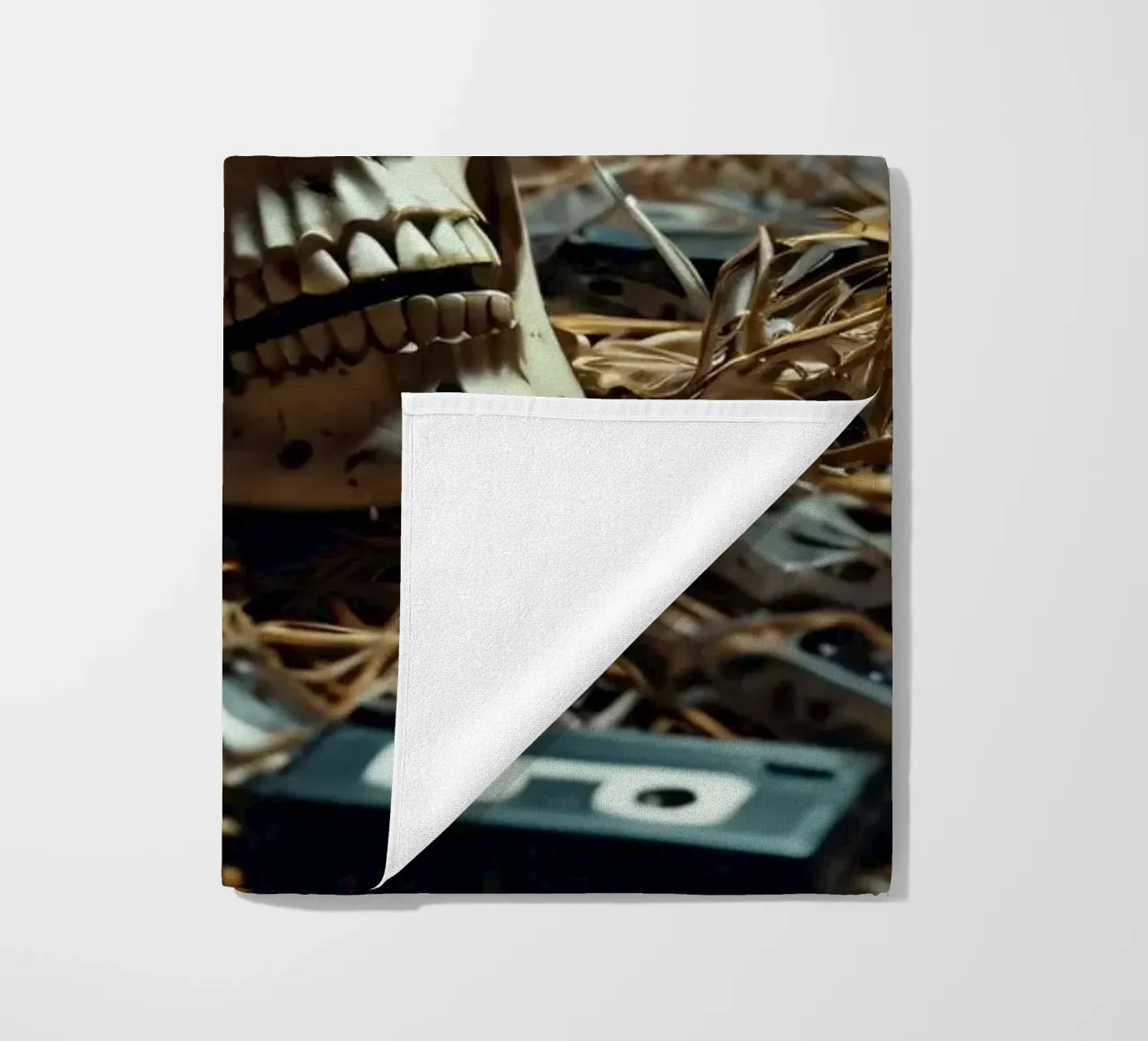 Un teschio che riposa tra vecchie cassette su un letto di paglia telo mare da DesignDoodle