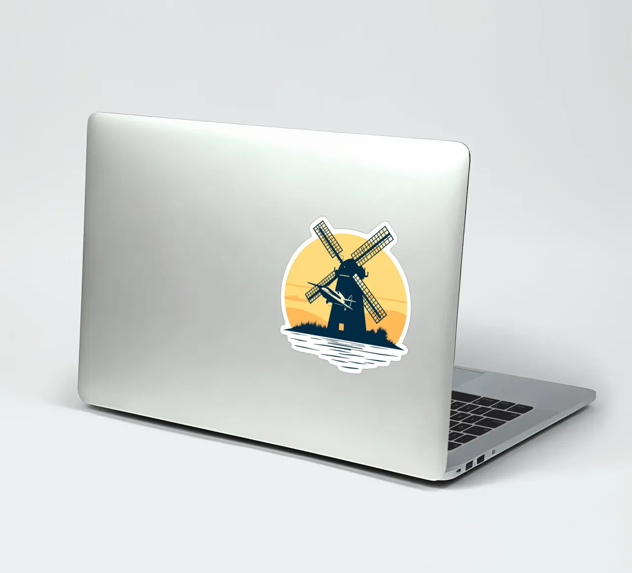 A silhouette of a windmill at sunset with an airplane flying sticker by DesignDoodle