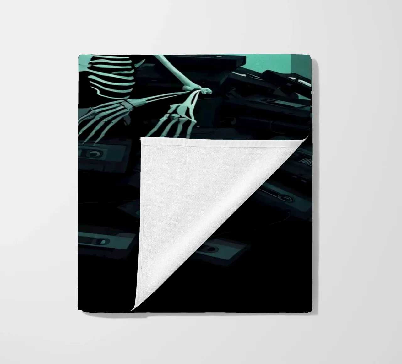 Uno scheletro siede tra vecchie cassette in un'atmosfera spettrale telo mare da DesignDoodle