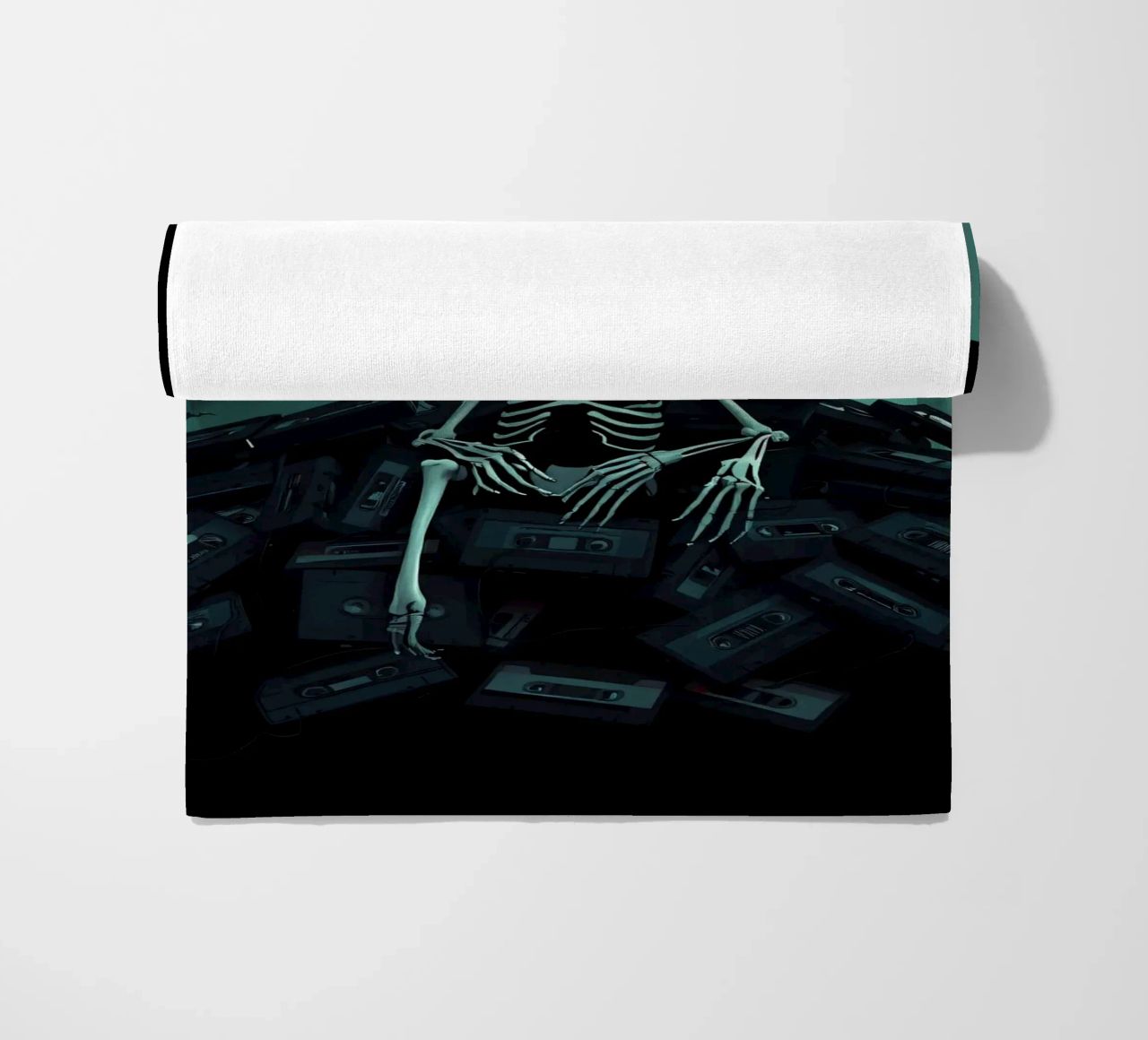Uno scheletro siede tra vecchie cassette in un'atmosfera spettrale telo mare da DesignDoodle