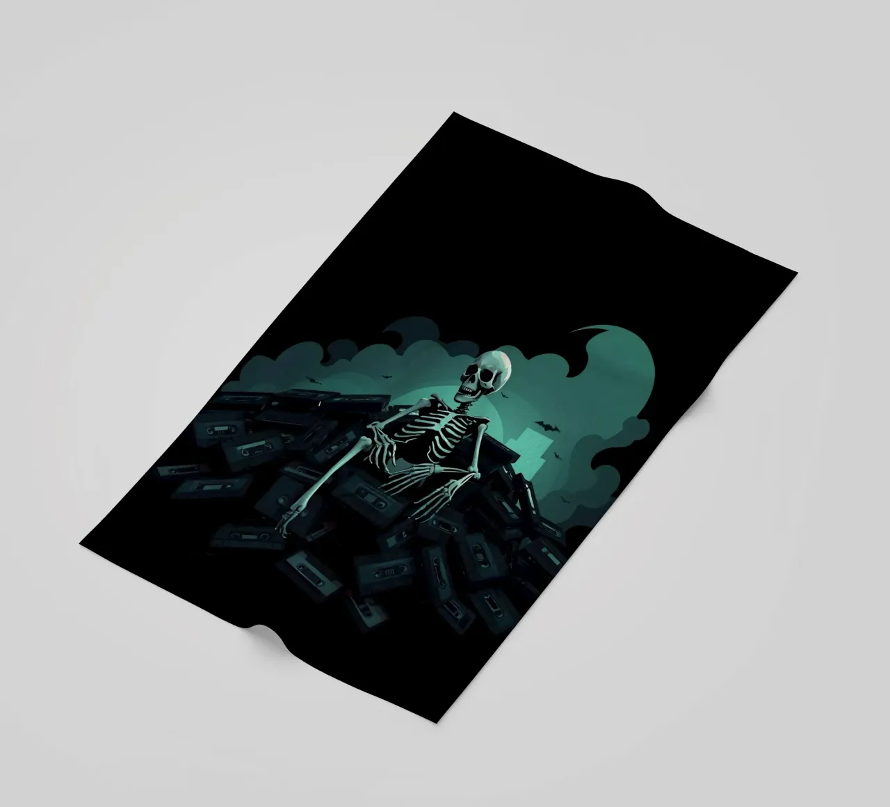 Uno scheletro siede tra vecchie cassette in un'atmosfera spettrale telo mare da DesignDoodle