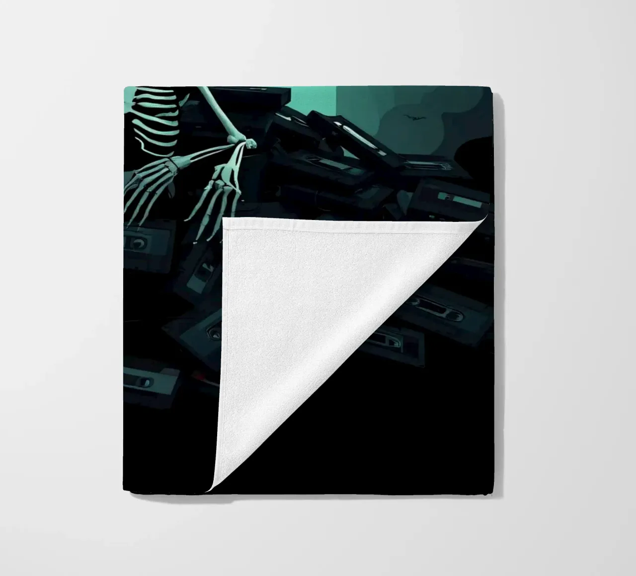 Uno scheletro siede tra vecchie cassette in un'atmosfera spettrale telo mare da DesignDoodle