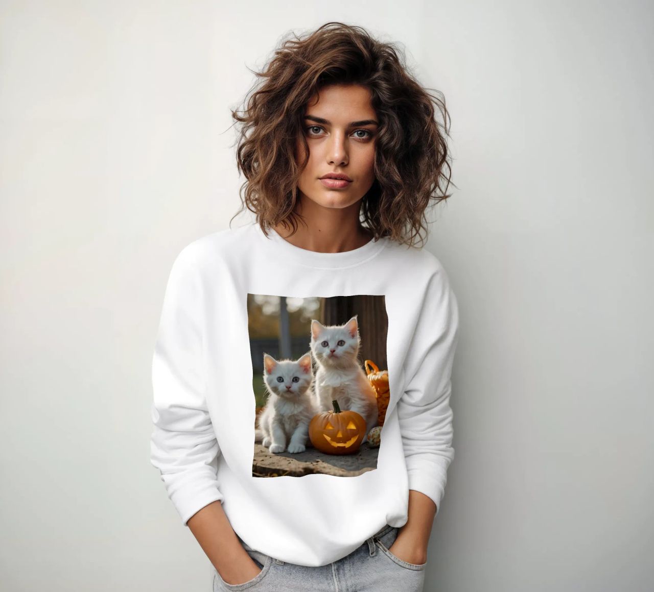 Dos gatitos juguetones junto a calabazas talladas y una cesta sudadera de DesignDoodle