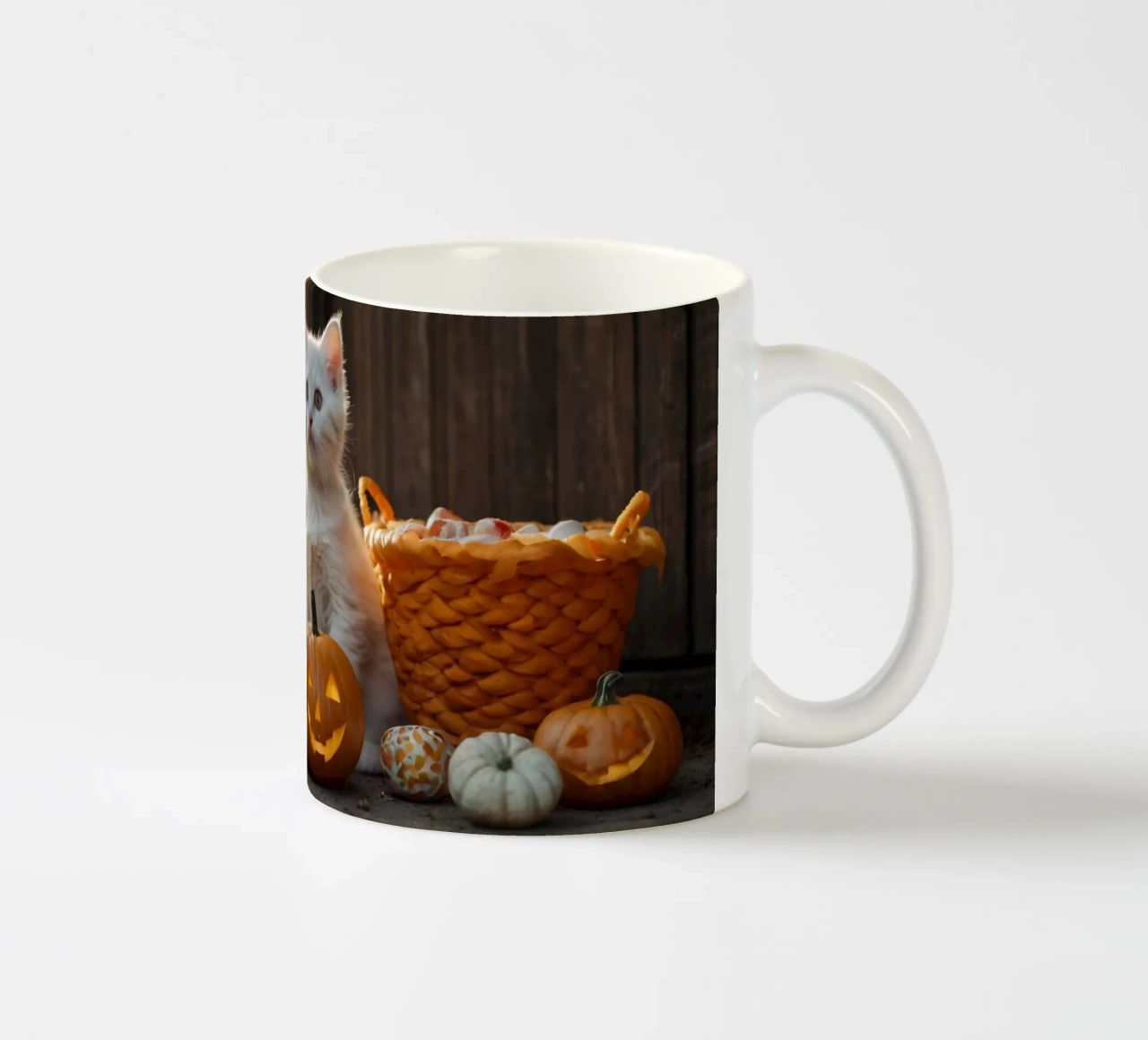 Due gattini giocherelloni accanto a zucche intagliate e a un cestino tazza in ceramica da DesignDoodle