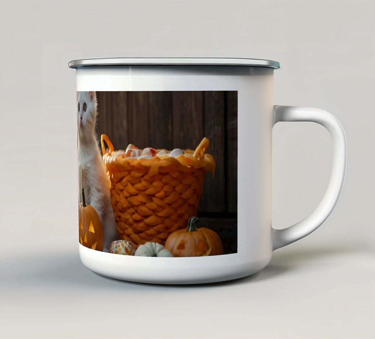 Due gattini giocherelloni accanto a zucche intagliate e a un cestino tazza in smalto da DesignDoodle