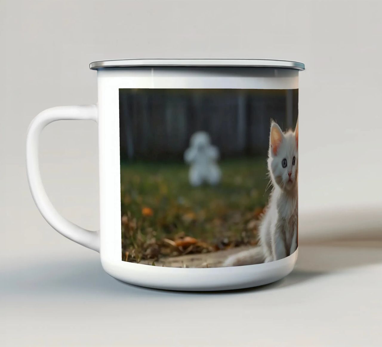 Due gattini giocherelloni accanto a zucche intagliate e a un cestino tazza in smalto da DesignDoodle