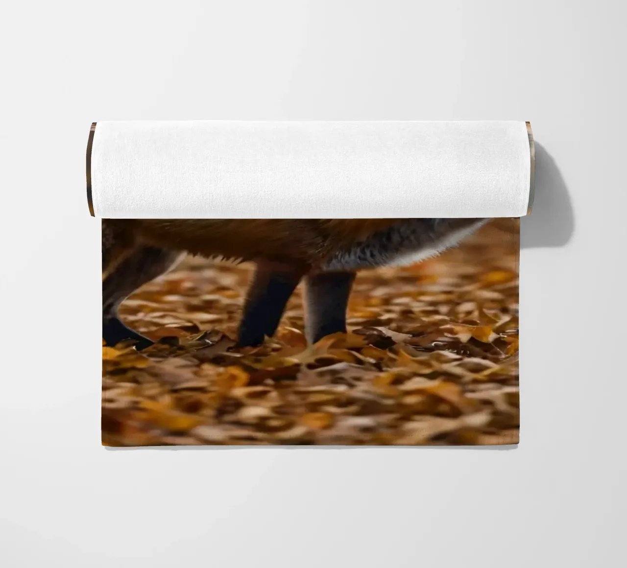 Renard marchant gracieusement dans une forêt couverte de feuilles d'automne serviette de plage de DesignDoodle