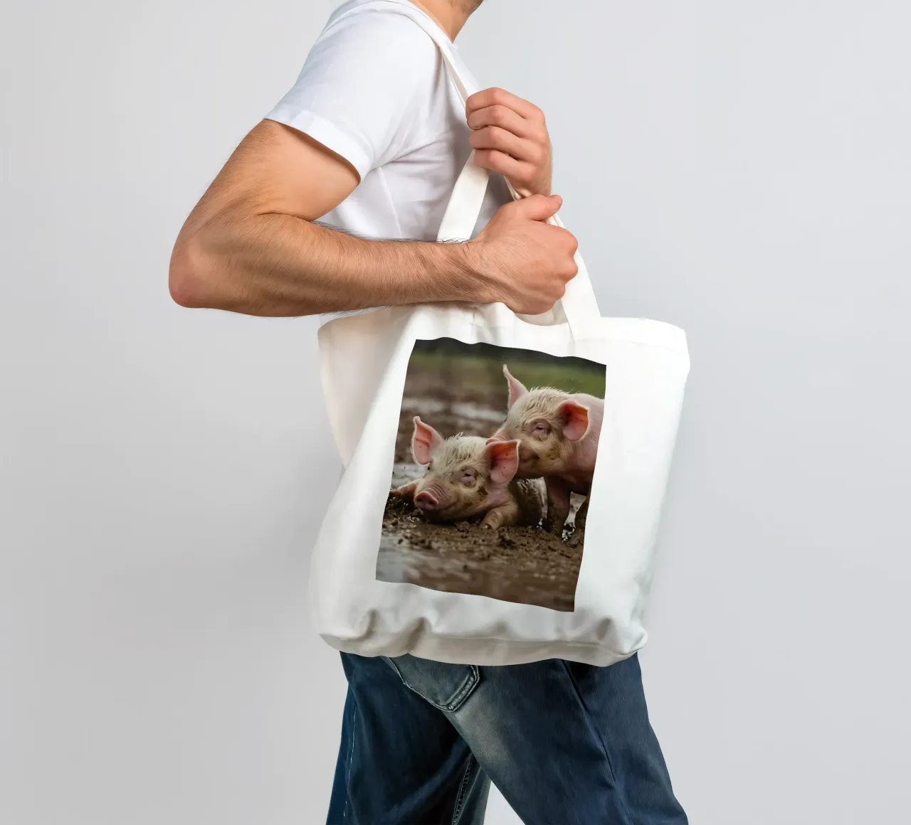 Two playful piglets enjoying muddy ground on a farm tote bag by DesignDoodle