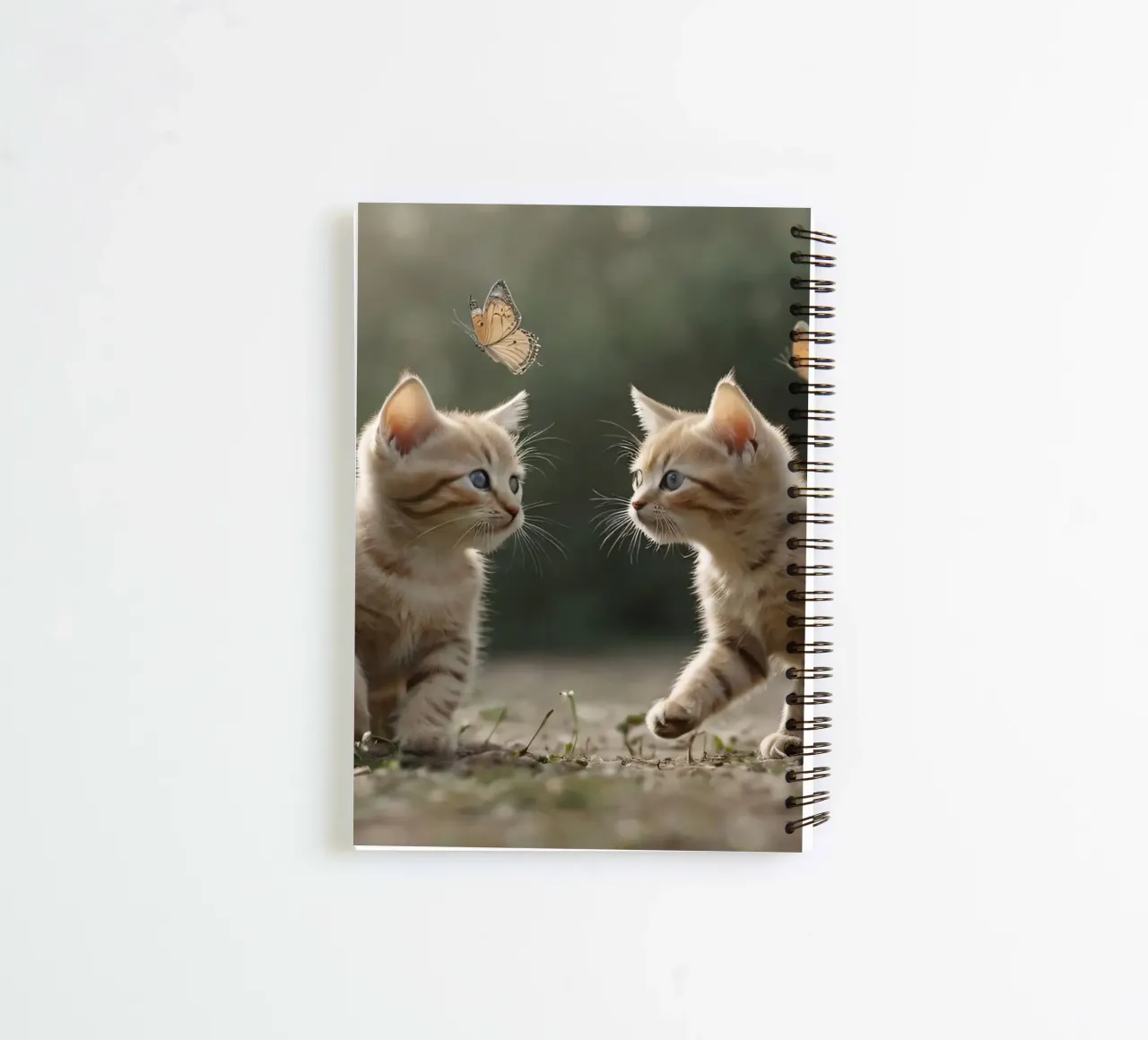Two playful kittens chase butterflies in a sunlit garden spiral notebook by DesignDoodle