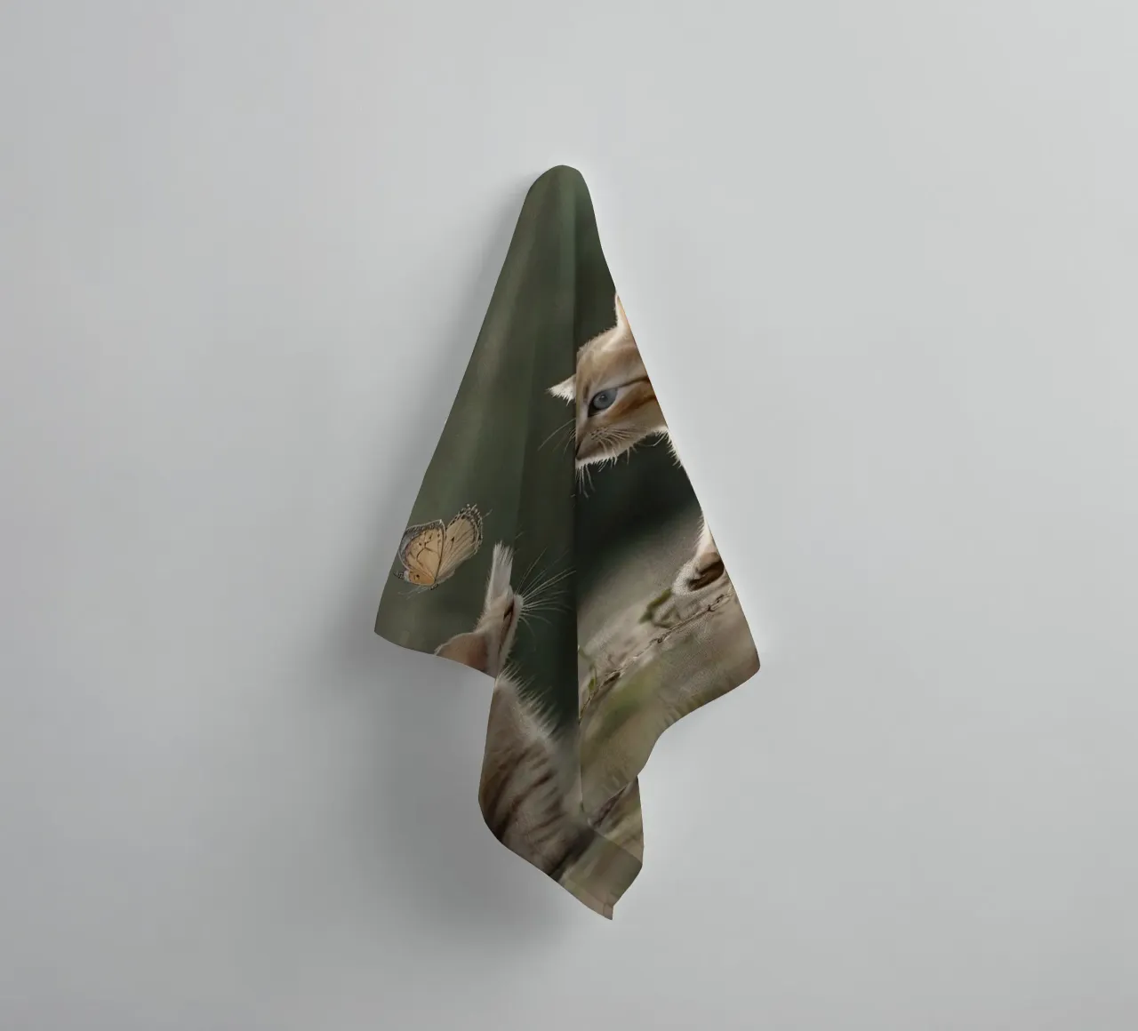 Two playful kittens chase butterflies in a sunlit garden towel by DesignDoodle
