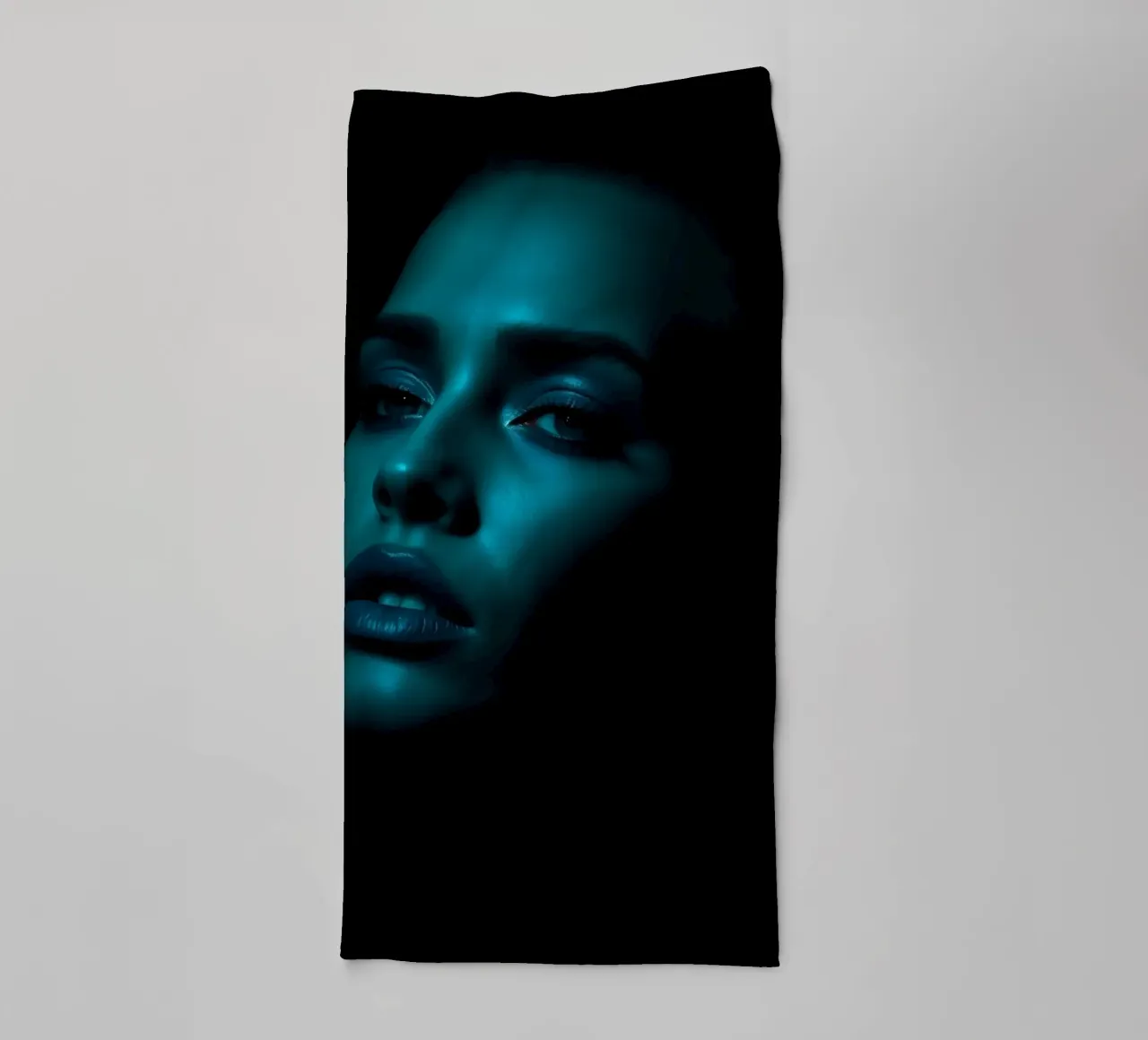 Portrait saisissant d'une femme illuminée par un bleu captivant serviette de bain de DesignDoodle